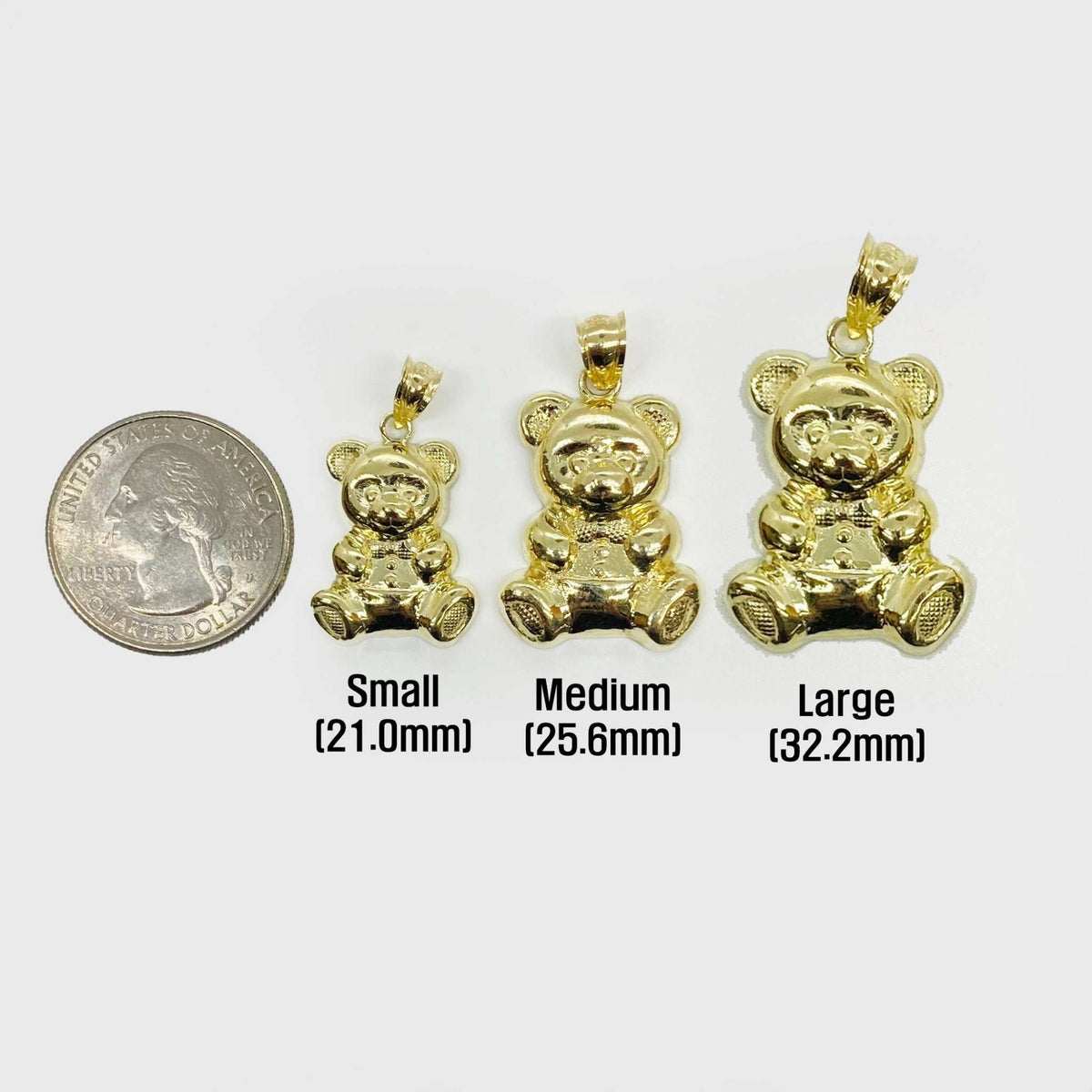Small, medium, and large 10k gold teddy bear pendants compared with a quarter.