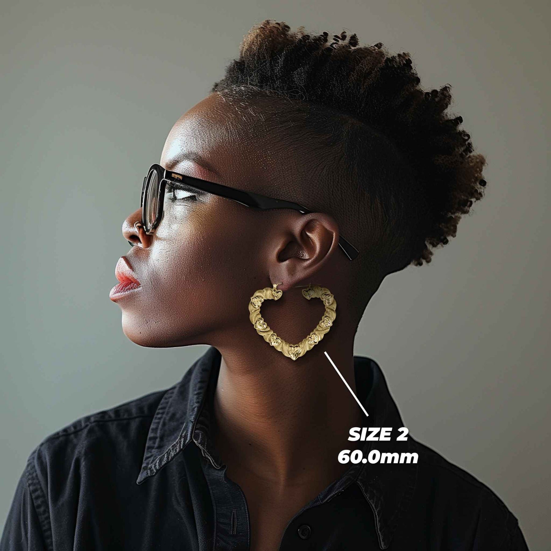 Woman wearing 60mm 10k gold twisted heart hoop earrings for size reference.