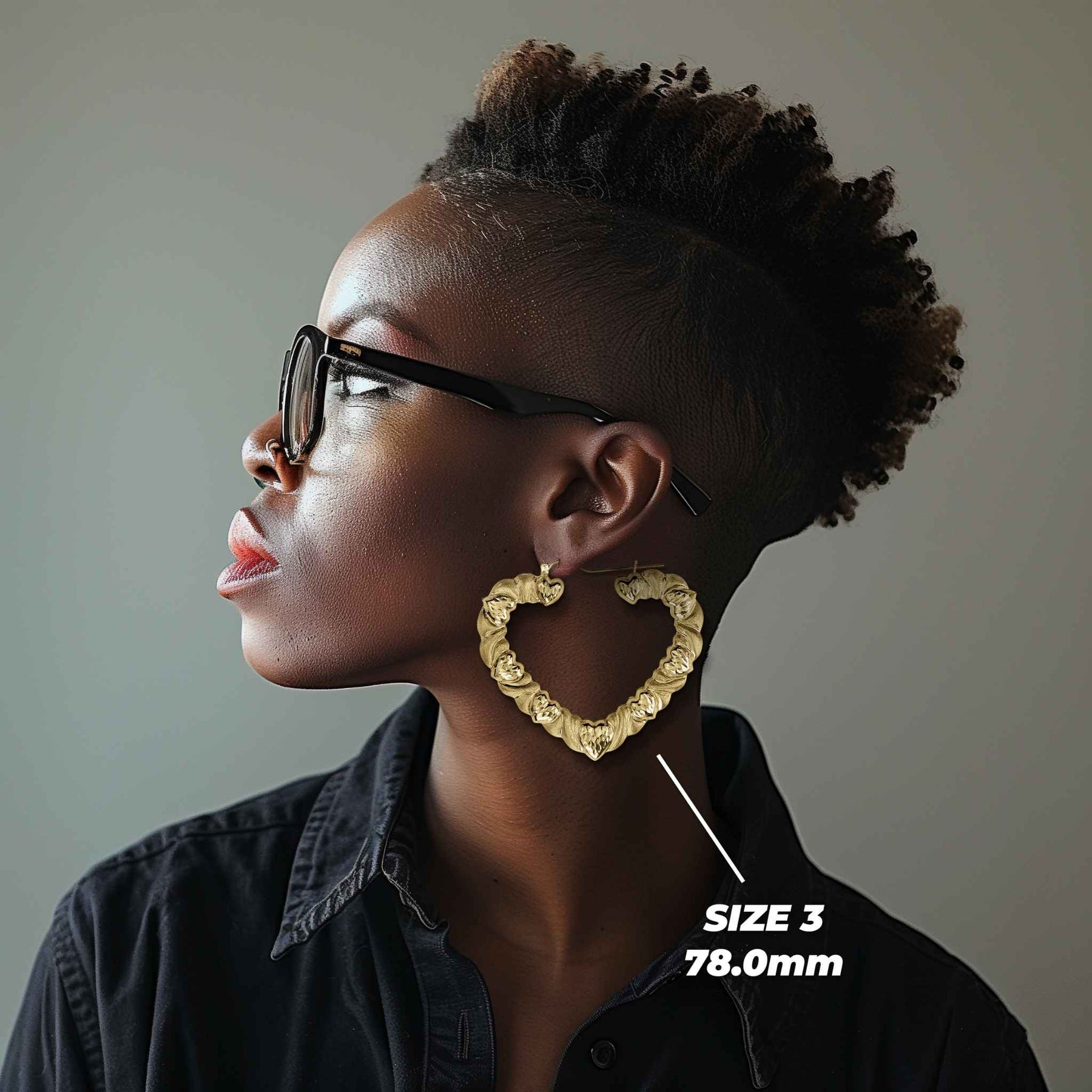Model wearing the largest 78mm 10k gold twisted heart hoop earrings for scale.