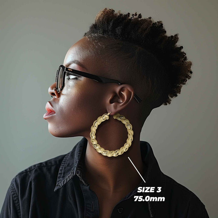 Side profile of a woman wearing 75mm 10k gold twisted round hoop earrings.