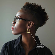 Side profile of a model wearing the 35.0mm Size 2 gold twisted square hoop.
