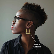 Side profile of a model wearing the 42.0mm Size 3 gold twisted square hoop.