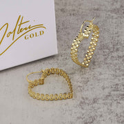 Pair of 10k yellow gold heart-shaped rollie hoop earrings resting beside a Nolters jewelry box.