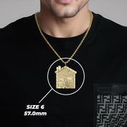 Model wearing a gold trap house pendant with Size 6 57.0mm label.