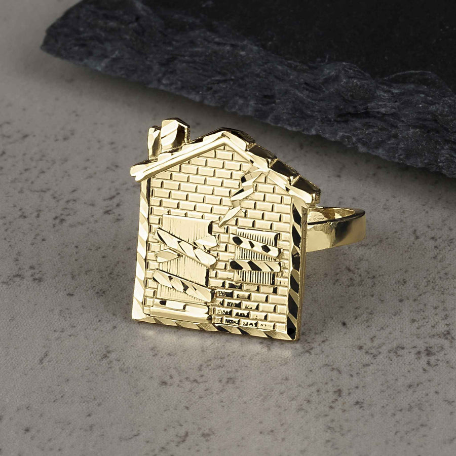 10k yellow gold ring featuring a detailed house design with diamond-cut brick patterns.