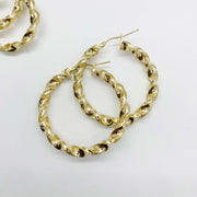 Pair of 10k gold twisted hoop earrings with a textured design on white background.