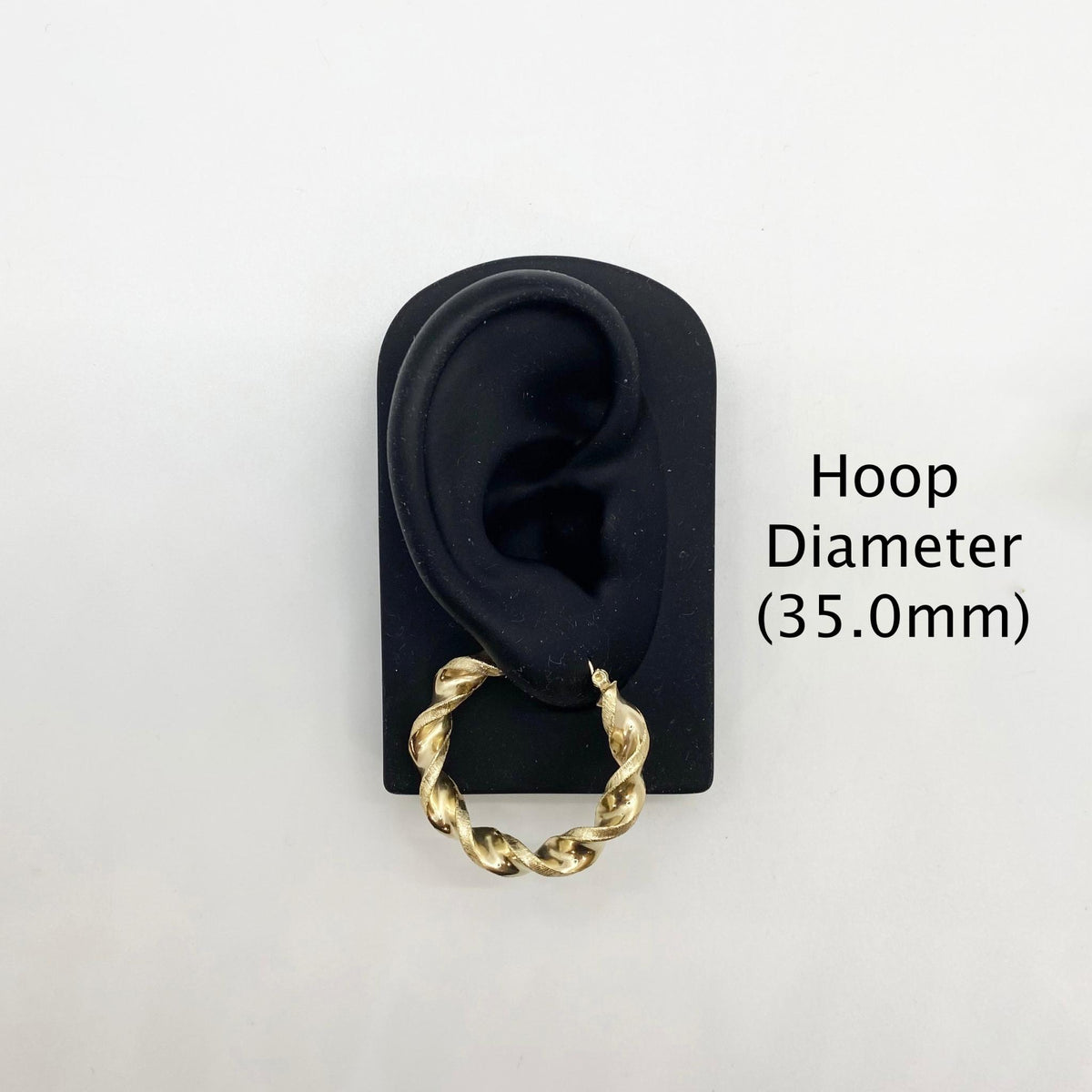 35.0mm 10k gold twisted hoop earring on a black display stand.