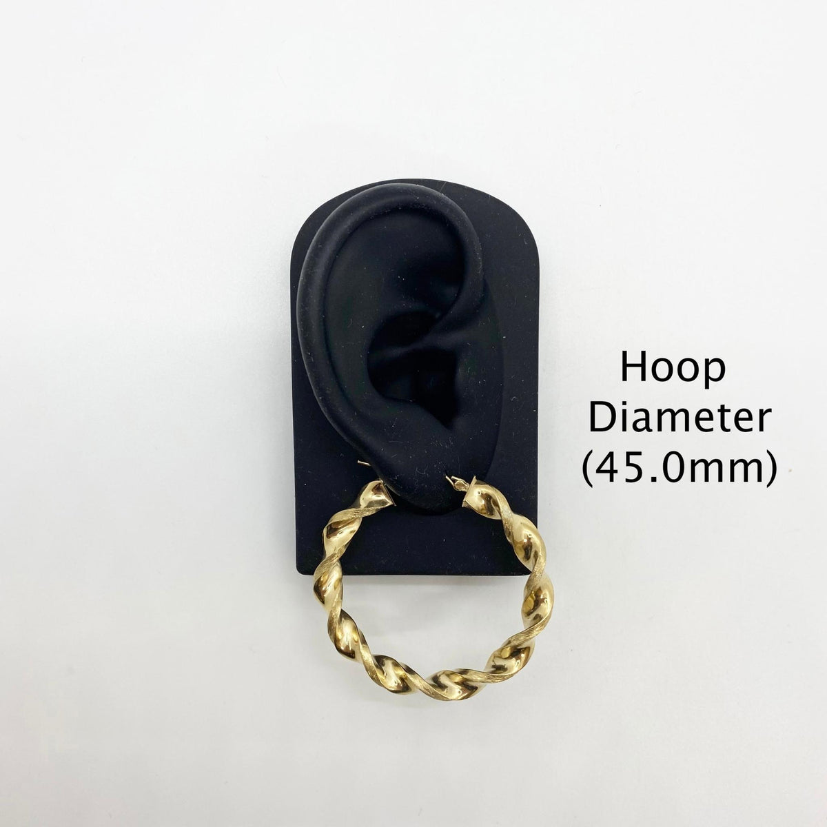 45.0mm 10k gold twisted hoop earring on a black display stand.
