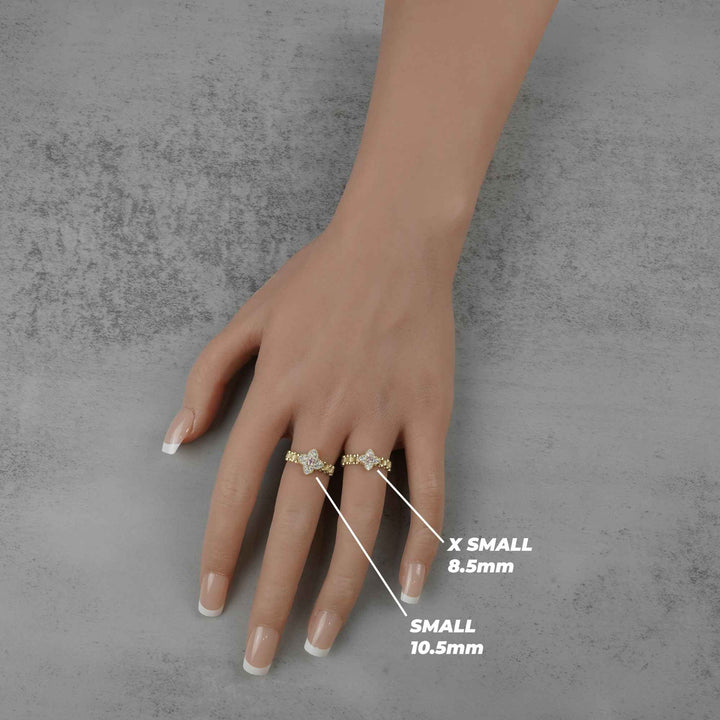 Hand wearing two 10k Clover Rollie rings with size reference on a gray background