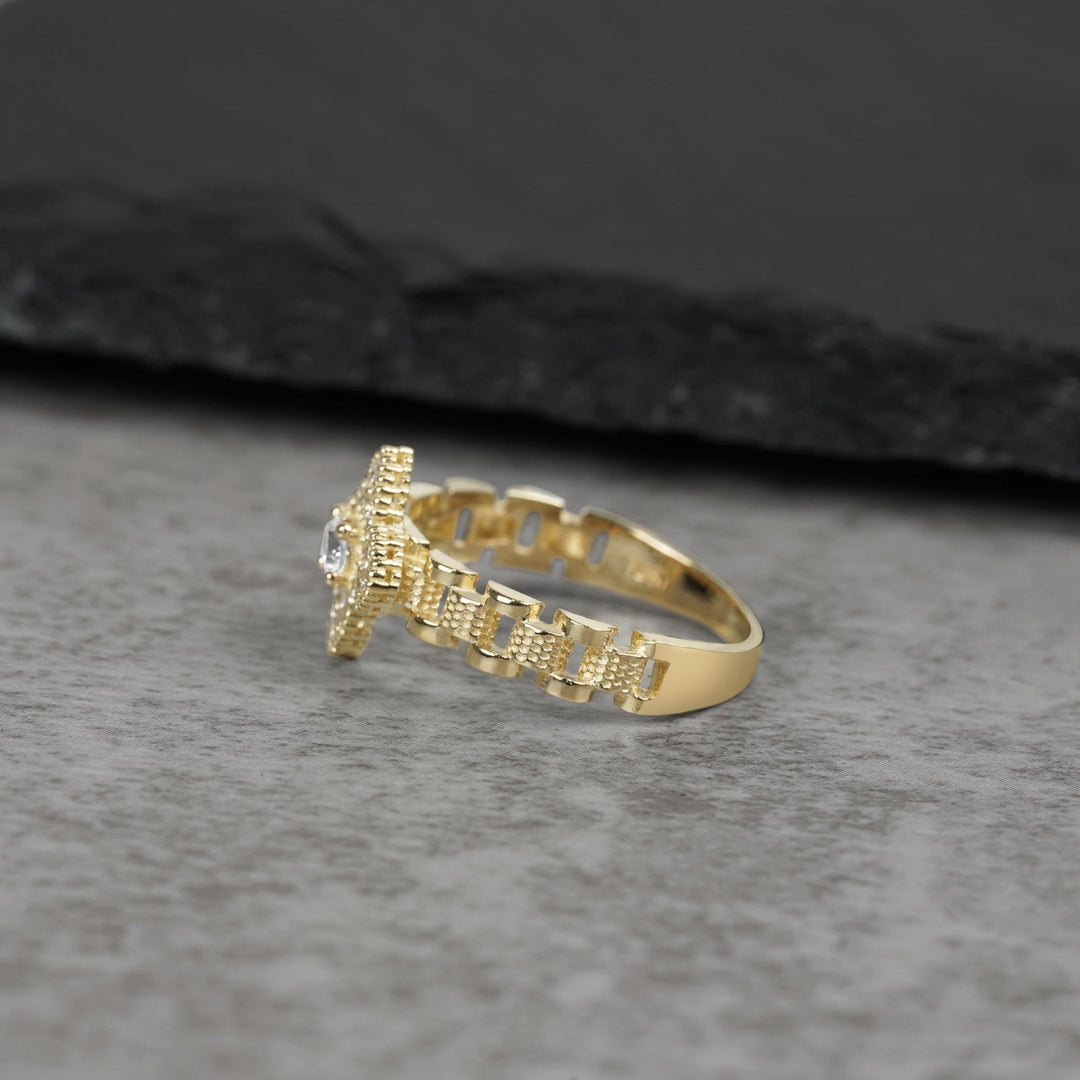 Side view of a 10K gold ring with cubic zirconia on a gray surface.