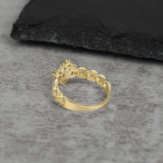 10k Gold ring with intricate design back view on a gray surface