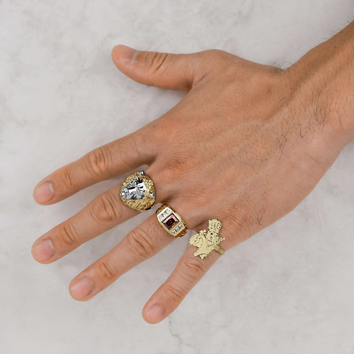 Hand wearing 10k Gold Vintage Pillsbury Doughboy DC Ring alongside a lion ring and ruby ring.