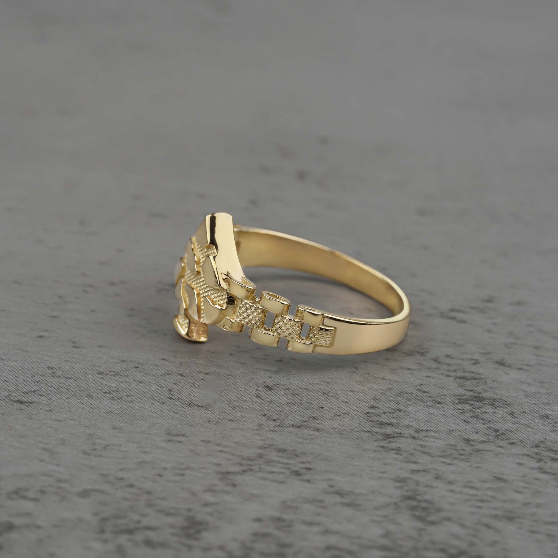 10k gold vintage nugget ring with spade design side view on a gray background
