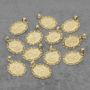 Ten solid 10k yellow gold zodiac pendant charms with ornate filigree borders and raised symbols, arranged on a textured gray background.