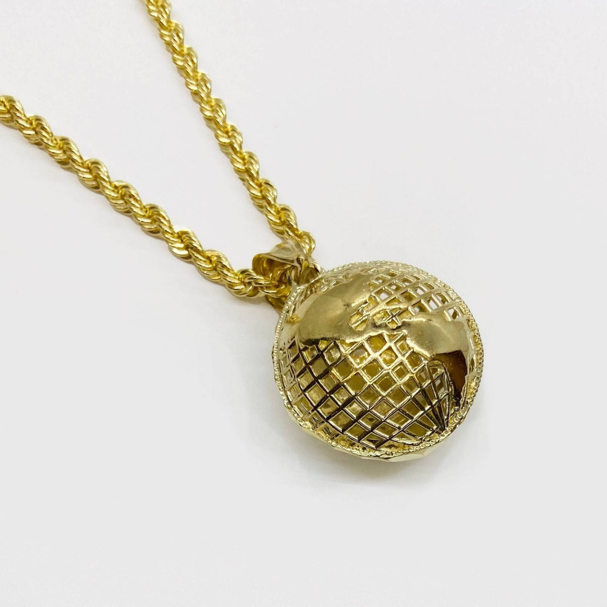 10k yellow gold 3D world globe pendant charm attached to a gold rope chain.