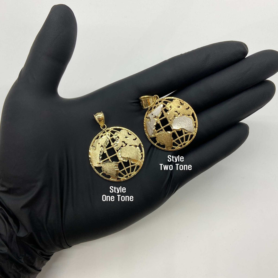 Gloved hand holding one-tone and two-tone gold globe pendants for style comparison.
