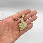 10k yellow gold iced-out thumbs up CZ pendant charm resting on an open hand