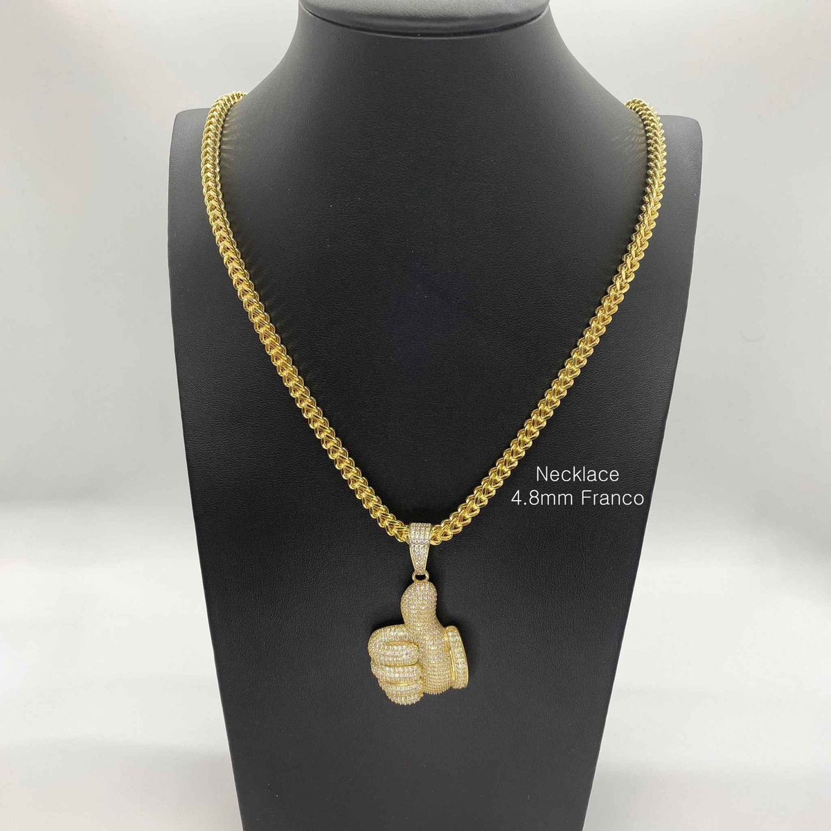 10k yellow gold iced-out thumbs up CZ pendant on a 4.8mm Franco chain displayed on a mannequin.