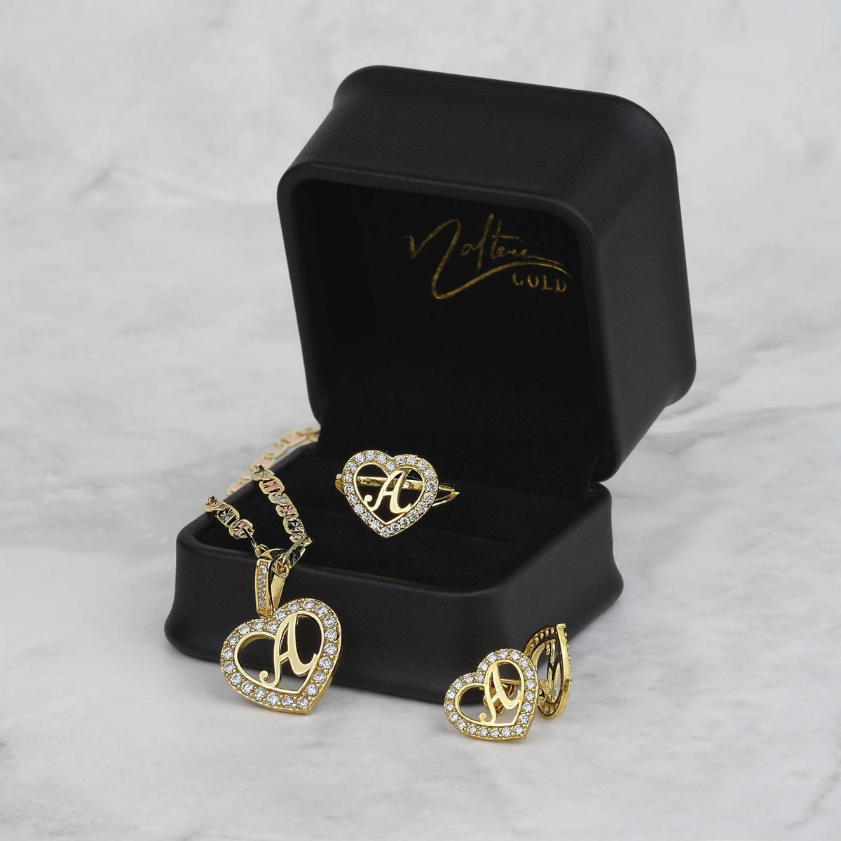 10k gold initial "A" heart necklace, ring, and earrings set displayed with gift box.