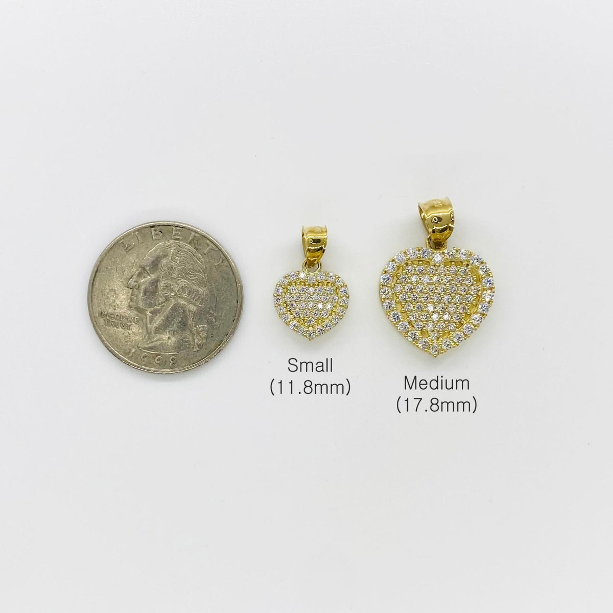 Small and medium 10k gold CZ heart pendants compared in size with a quarter.