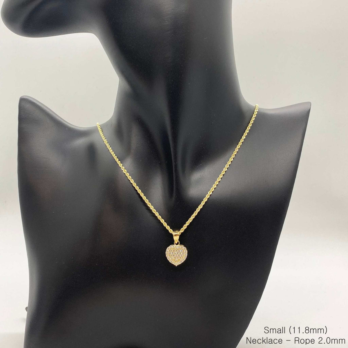 Small 10k gold CZ heart pendant necklace displayed on a black jewelry mannequin bust.
