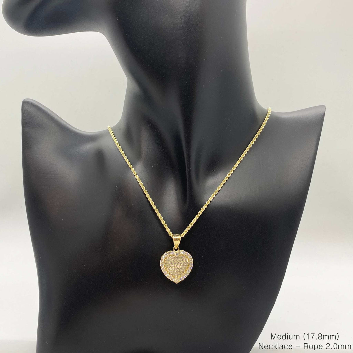 Medium 17.8mm 10k gold CZ heart pendant necklace on a black display bust.