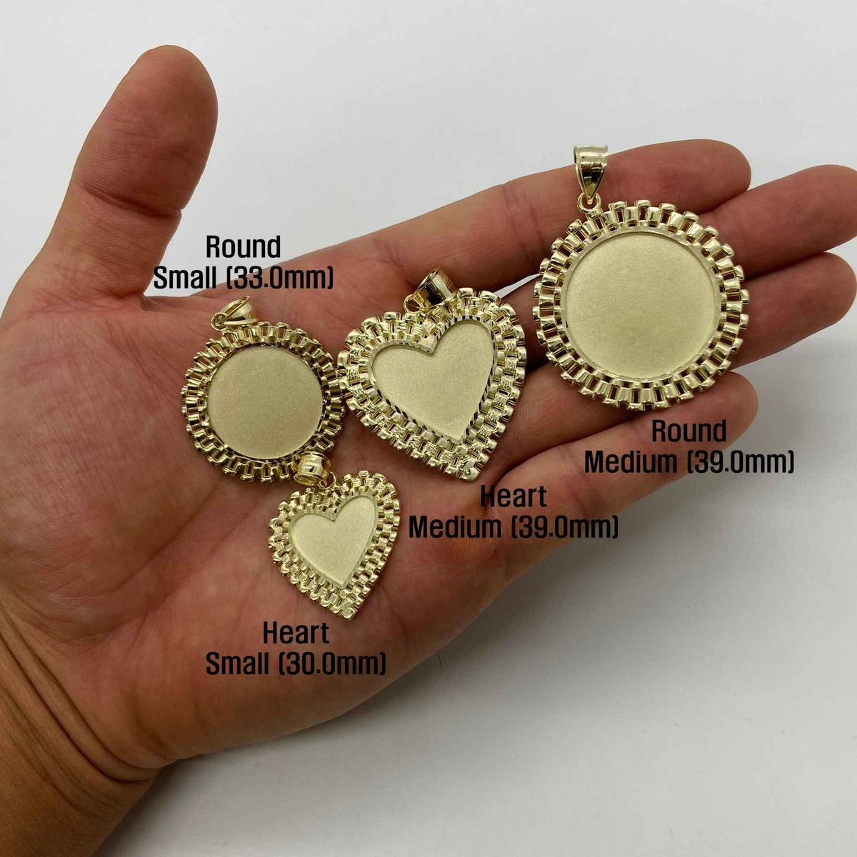 Size comparison of four gold picture pendant frames displayed across an open hand