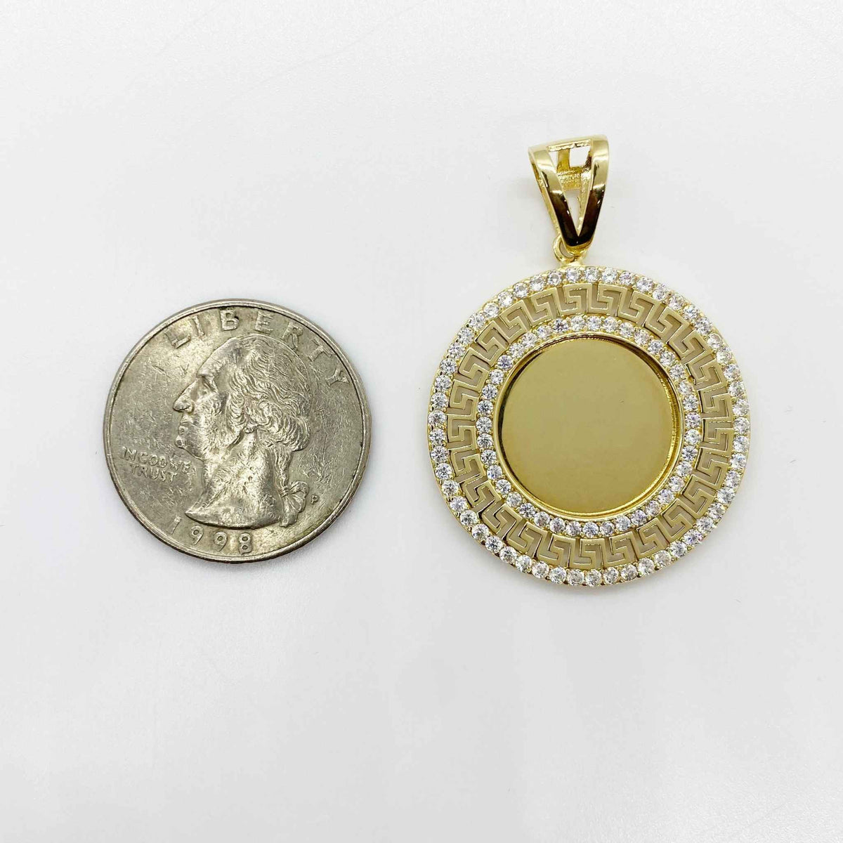 Round gold Greek key memorial picture pendant shown next to a US quarter coin.