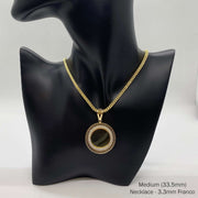 Medium gold CZ round picture pendant on Franco chain on black mannequin.