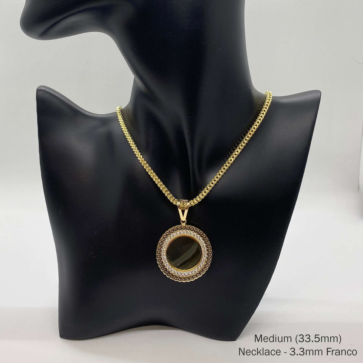 Medium gold CZ round picture pendant on Franco chain on black mannequin.