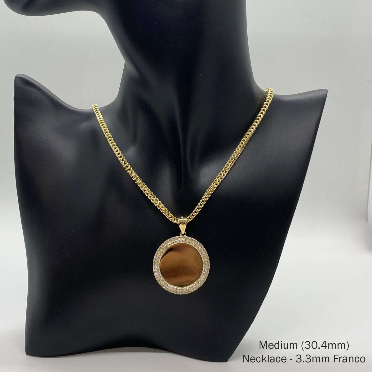 Gold round CZ photo pendant on a mannequin display labeled Medium 30.4mm and 3.3mm Franco necklace.