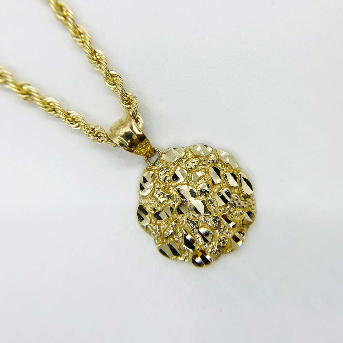 Front view of 10k gold round nugget pendant featuring textured surface on rope chain.