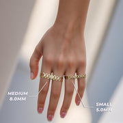 Hand wearing small and medium gold watch-link two-finger rings with text overlays indicating measurements.