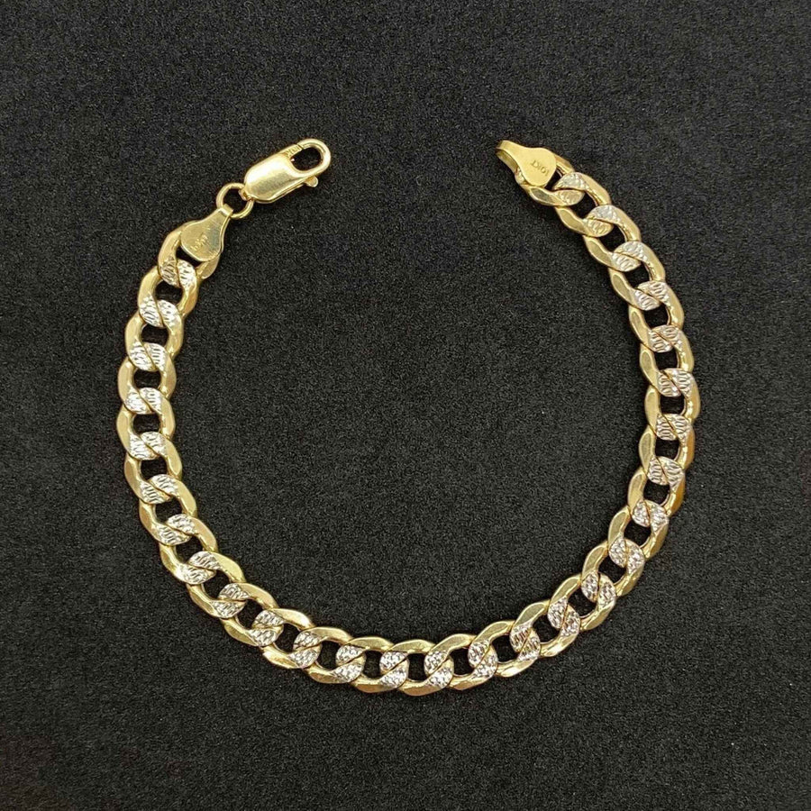 Polished 10k yellow gold Cuban link bracelet featuring diamond-cut pave details.