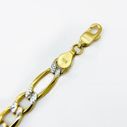 Close-up of a 10k gold pave Figaro link bracelet showing a lobster clasp and hallmark.