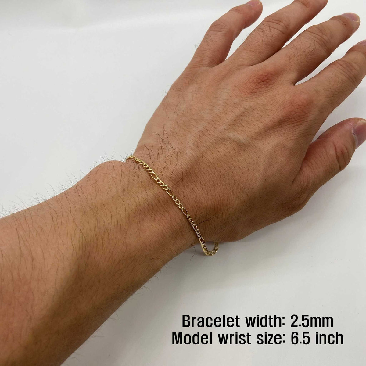 Close-up of a model wearing a 2.5mm 10k gold pave Figaro link bracelet on wrist.
