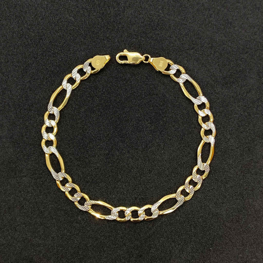 10k gold pave Figaro link chain bracelet displayed on a dark textured background.
