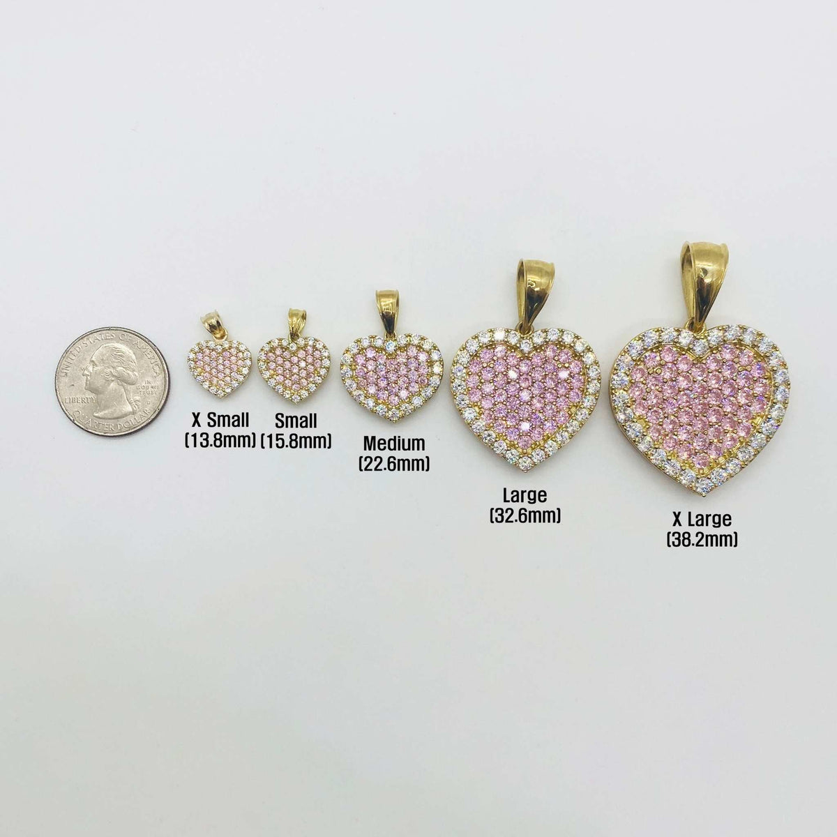 Five sizes of pink CZ gold heart pendants shown next to a US quarter.
