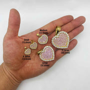 Hand holding five sizes of pink CZ gold heart pendants with millimeter size labels.