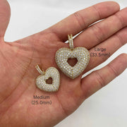Medium and Large gold CZ heart pendants held in hand with millimeter labels.