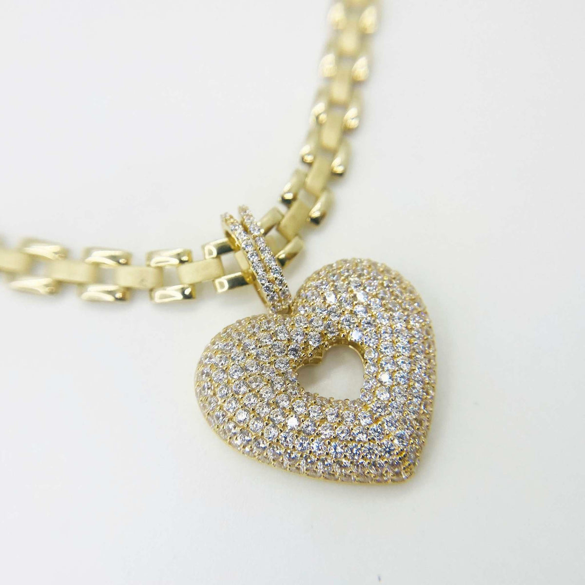 Close-up of 10k gold CZ puffy heart pendant on Rolex style link chain.