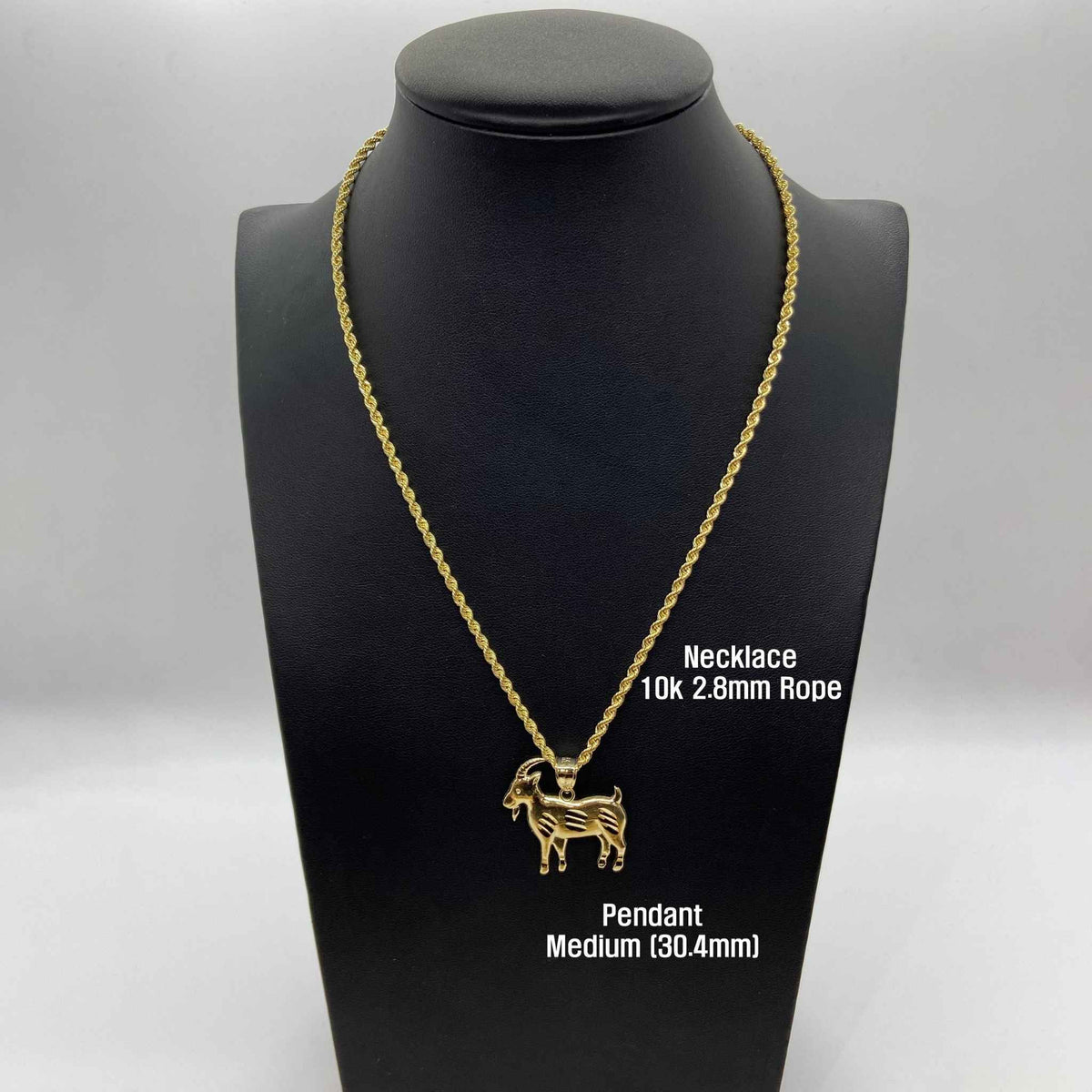 Yellow gold satin goat pendant necklace displayed on a black jewelry mannequin bust