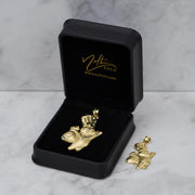 Open black Nolters box showing two 10k gold Pillsbury Doughboy pendants in different sizes.