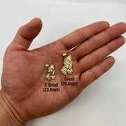 Two sizes of 10k solid gold praying hands pendants resting on an open palm