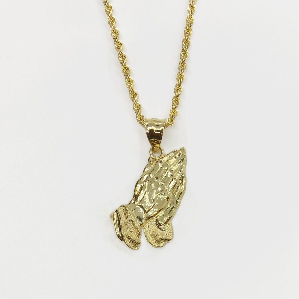 10k solid yellow gold praying hands pendant displayed on a matching gold rope chain.