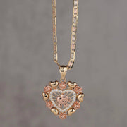 14k gold and rose gold heart pendant with elephant motif and floral border.