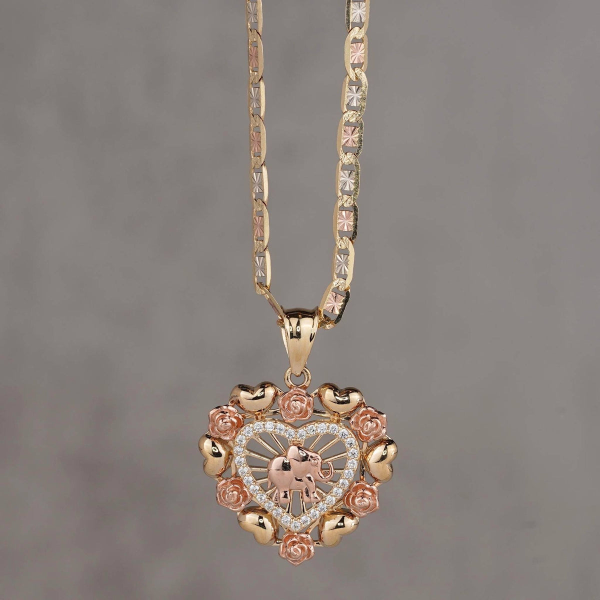 14k gold and rose gold heart pendant with elephant motif and floral border.