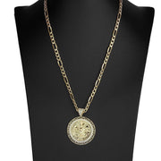 Gold Centenario medallion necklace featuring an intricate Greek key frame showcased on a black display stand.