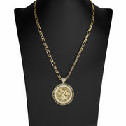 Gold Figaro chain necklace with a circular coin pendant displayed on a black jewelry bust.