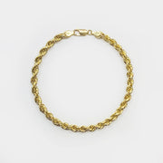A 14k gold classic rope chain bracelet displayed in a circle on white background.